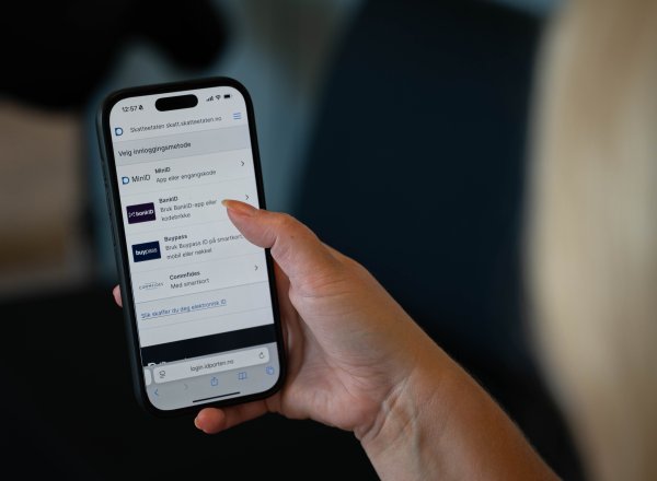 Bildet viser en person som logger inn med BankID på mobilen