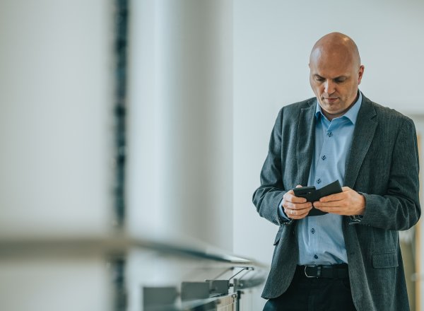 Sikkerheitsdirektør i Nkom, Svein Scheie, ser alvorleg på ein mobiltelefon.