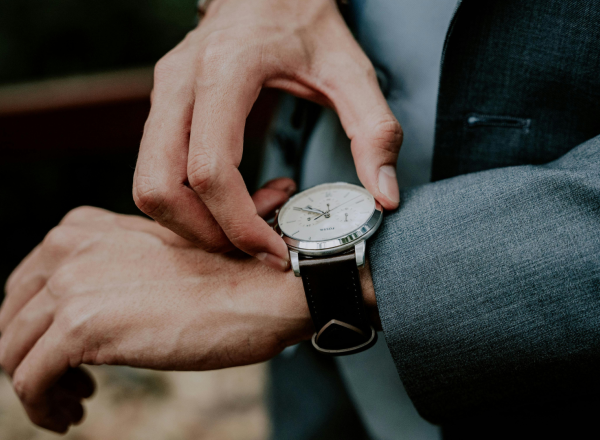 Mann ser på klokke. 