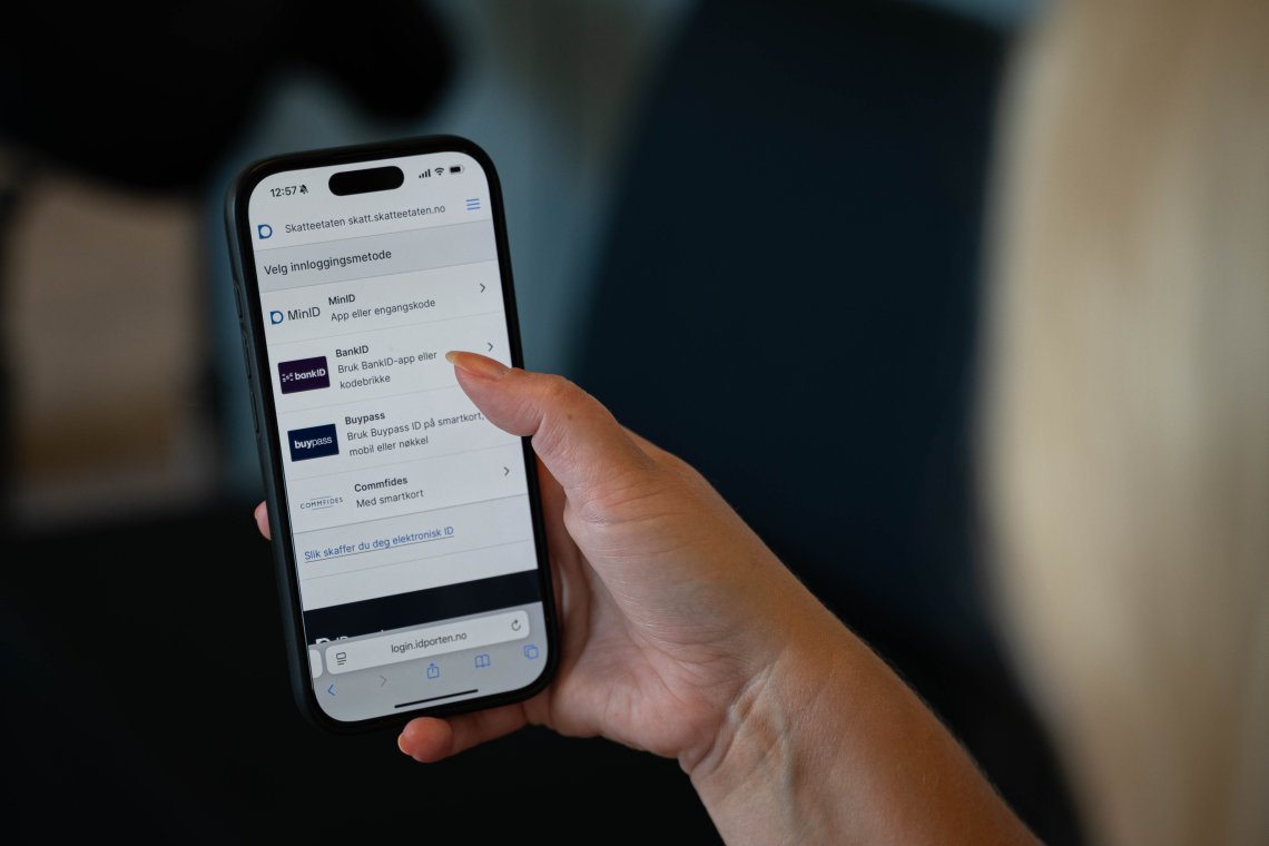 Bildet viser en person som logger inn med BankID på mobilen