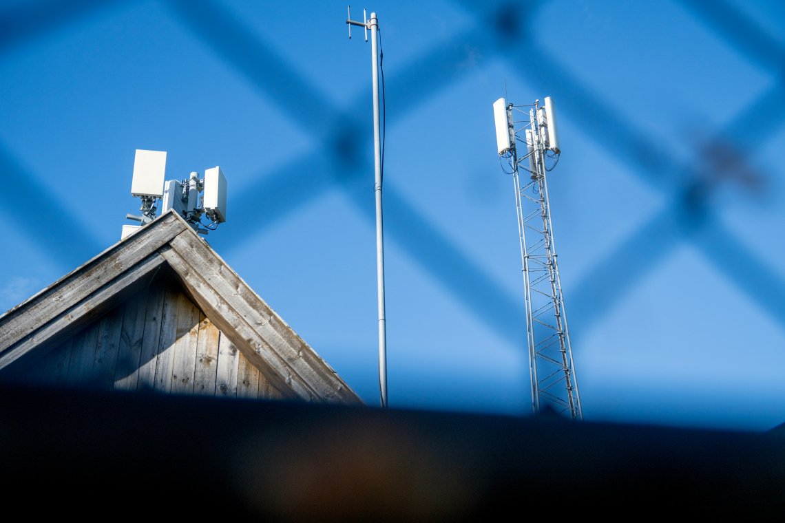 Mobilmaster og antenner mot blå himmel.